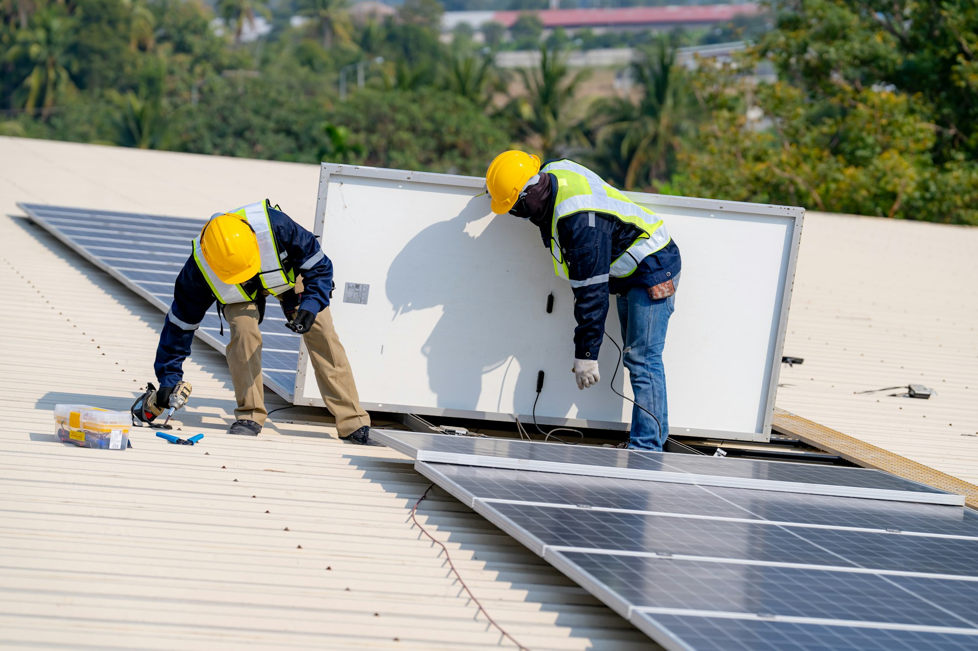 workers installing solar panels, for efficient energy on rooftop